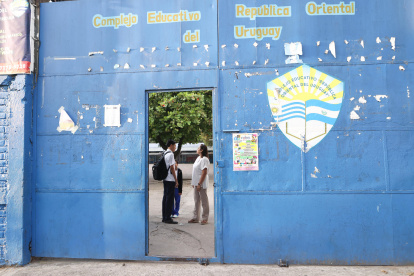 Una educadora del Complejo Educativo República Oriental del Uruguay, revisa el corte de cabello a un estudiante este miércoles, en San Salvador (El Salvador).