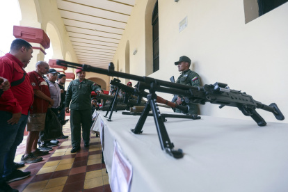 Un miembro de la guardia presidencial muestra armas durante una ceremonia de inducción para las personas que se enrolaron en la campaña de alistamiento de la Milicia Nacional Bolivariana.