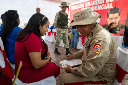 Un funcionario de la Milicia Bolivariana de Venezuela registra a una mujer durante una jornada de alistamiento este sábado, en Caracas (Venezuela).