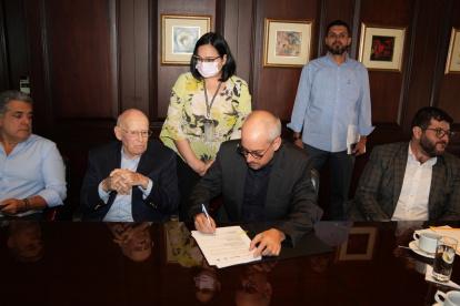 Representantes de TPG y de  la Cooperación Técnica Alemana GIZ firman un acuerdo.