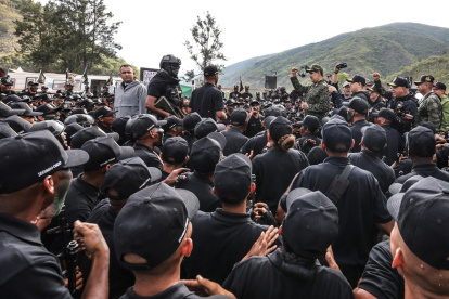 El presidente de Venezuela, Nicolás Maduro, levantando el puño frente a soldados del ejército en un campo de entrenamiento en Caracas.