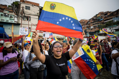 FOTODELDÍA AME4521. CARACAS (VENEZUELA), 29/08/2025.- Una persona sostiene una bandera de Venezuela en una manifestación este viernes, en Caracas (Venezuela). Simpatizantes del chavismo se movilizaron en comunidades de Venezuela para participar en la jornada de alistamiento de milicianos y reiterar su respaldo al presidente Nicolás Maduro ante lo que consideran "amenazas" de Estados Unidos, a cuyo Gobierno acusan de desplegar "buques de guerra" en el mar Caribe para intimidar a la nación petrolera. EFE/ Miguel Gutiérrez