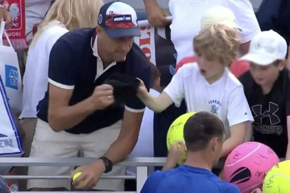Piotr Szczerek, director ejecutivo de la empresa polaca Drogbruk en el momento que le arrebata la gorra al niño.