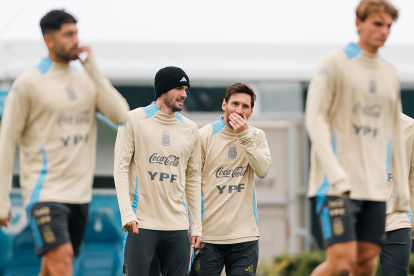 Los jugadores de la selección argentina de fútbol Lionel Messi (c-d) y Rodrigo De Paul (c-i) reaccionan durante un entrenamiento.