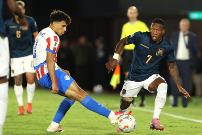 Diego Gómez Amarilla de Paraguay disputa el balón con Pervis Estupiñán de Ecuador en el duelo de eliminatororias sudamericanas.