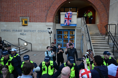 Un manifestante (arriba en el centro) es arrestado poco después de intentar colgar una bandera de la Unión afuera de las oficinas del consejo en Epping, al noreste de Londres.