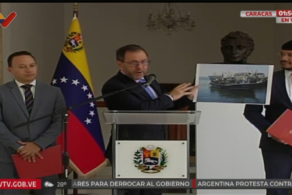 Captura de video cedido por VTV que muestra al canciller de Venezuela, Yván Gil (c), sosteniendo la imagen de una embarcación este sábado, en Caracas (Venezuela). El Gobierno de Venezuela aseguró que un "destructor" de Estados Unidos abordó de manera "ilegal" y ocupó durante ocho horas una embarcación venezolana con "nueve pescadores" que estaban -subrayó- en aguas del país suramericano, todo esto, según Caracas, con la intención de justificar "una escalada bélica" en el Caribe. EFE/ VTV /SOLO USO EDITORIAL/ NO VENTAS/ SOLO DISPONIBLE PARA ILUSTRAR LA NOTICIA QUE ACOMPAÑA (CRÉDITO OBLIGATORIO)