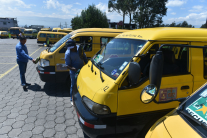 Varios expresos escolares en un estacionamiento en Quito.