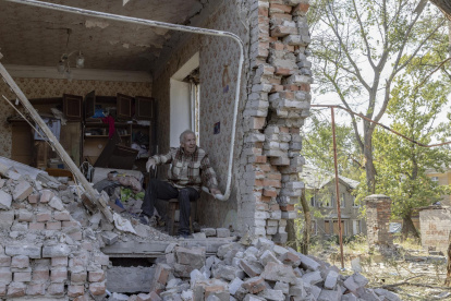 Un adulto mayor que se negó a evacuar, sentado entre los escombros de un edificio dañado, mientras los miembros de "Ángeles Blancos" ayudan a evacuar de la ciudad de Kostiantynivka.