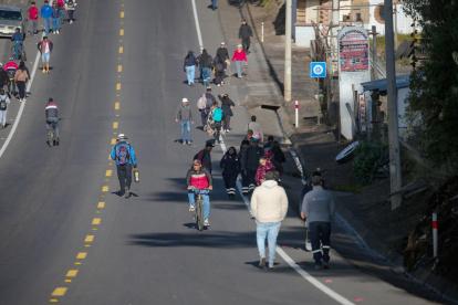 Personas transitan una vía este martes, en Tabacundo (Ecuador).