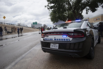 Un auto de la Policía de Dallas aparcado tras un tiroteo en la oficina local del Servicio de Inmigración y Control de Aduanas (ICE), en Dallas, Texas, EE.UU.