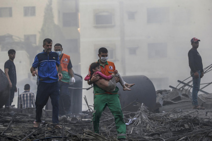 Un palestino carga a una niña herida tras recuperarla de los escombros de una zona destruida tras los ataques aéreos israelíes en la ciudad de Gaza.