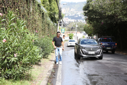 En Cumbayá, los vecinos caminan por la calzada ante la ausencia de aceras o porque estas permanecen bloqueadas por la vegetación.