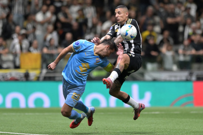 Guilherme Arana (d) de Atlético Mineiro disputa el balón con Leonel Justiniano (i) de Bolívar este miércoles, en un partido de los cuartos de final de la Copa Sudamericana entre  Atlético Mineiro y Bolívar en el estadio Arena MRV, en Belo Horizonte (Brasil).