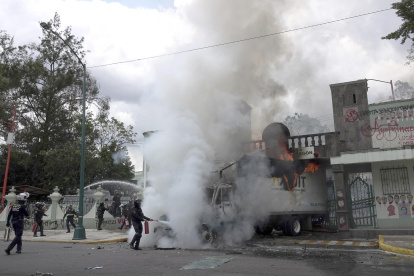 Policías intentan sofocar el fuego de un camión vandalizado en las instalaciones del Campo Militar en la Ciudad de México (México).