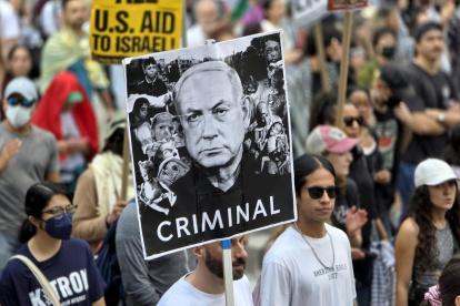 Una persona sostiene un cartel con el rostro del primer ministro israelí, Benjamin Netanyahu, durante una manifestación en contra de la guerra de Gaza en Nueva York (Estados Unidos).