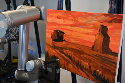 Robot. Un brazo robótico pinta un lienzo en el estudio Acrylic Robotics.