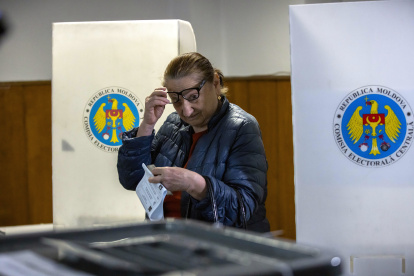 Una mujer deposita su voto en un colegio electoral.