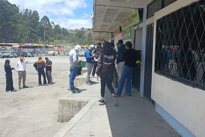 Policías inspeccionan encomiendas en el terminal terrestre de Loja durante operativo de incautación de explosivos.