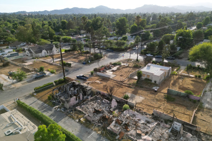 Lotes residenciales despejados después de que las casas allí fueran destruidas en el incendio de Eaton de enero de 2025, junto a casas que aún están en pie, en Altadena, California.