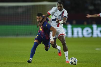 Willian Pacho (D), de PSG, sobre la marca al delantero del FC Barcelona, Ferrán Torres en Champions League.