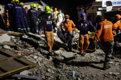 Equipos de rescate sobre un edificio derrumbado en Filipinas a raíz de un fuerte terremoto.