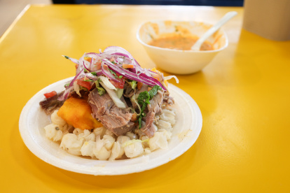 El hornado, un plato insignia de la ciudad que combina papa, choclo, mote, salsa criolla y ají casero.