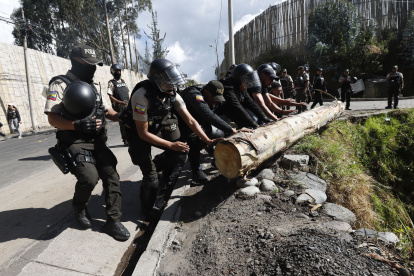 Policías retiran un tronco de la carretera, que fue puesto por los que quieren que el diésel tenga subsidio.