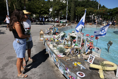 La gente lleva rosas para colocarlas en un monumento en Tel Aviv en memoria de los israelíes asesinados durante y en los dos años transcurridos desde los ataques de 2023.