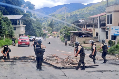 Equipos de la fuerza pública retiran piedras y escombros colocados por manifestantes en la vía Loja–Cuenca.