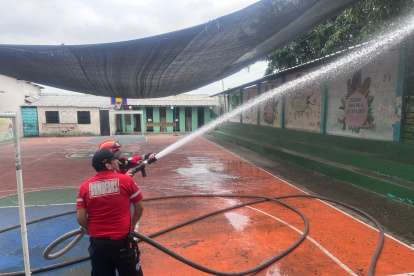 Personal del Cuerpo de Bomberos de Balzar limpió la escuela donde se reportaron los casos de intoxicación.