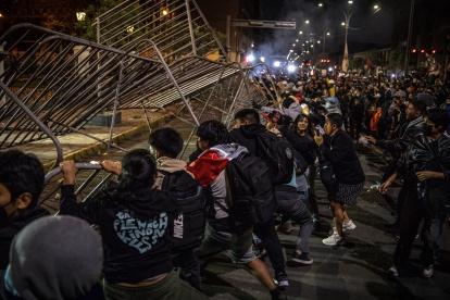 Personas tumban una valla durante una manifestación en Lima (Perú), en una fotografía de archivo.