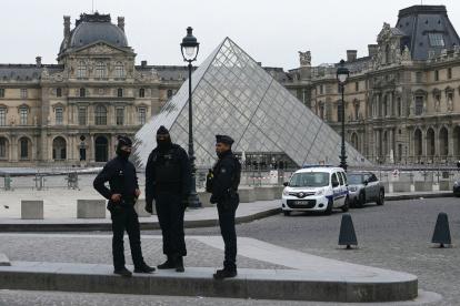 Agentes de policía franceses se sitúan frente al Museo del Louvre tras un robo, en París, este domingo 19 de octubre de 2025.