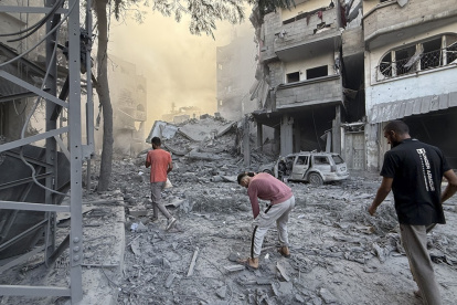 Varios hombres caminan por los escombros tras uno de los ataques que sufrió Gaza este domingo 19 de octubre.