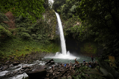 Fotografía del 3 de octubre de 2025 de un grupo de turistas en la catarata La Fortuna en los alrededores del volcán Arenal en la Fortuna (Costa Rica).