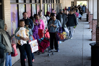 La gente hace fila para recibir alimentos para los trabajadores federales suspendidos en No Limits Outreach Ministries el 21 de octubre de 2025 en Hyattsville, Maryland.