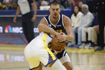 Nikola Jokic (detrás) fue la estrella de Nuggets en su debut ganador.
