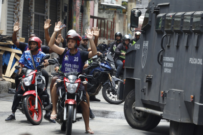 Personas reaccionan durante un operativo de la Policía d Río de Janeiro este martes, en Río de Janeiro (Brasil).