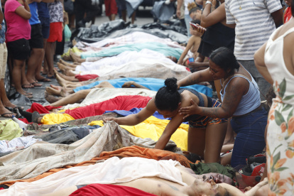 Una mujer observa un cuerpo sin vida en una calle este miércoles, en Río de Janeiro (Brasil).