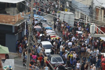 Personas observan cuerpos sin vida en una calle este miércoles, en Río de Janeiro (Brasil).