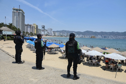 Agentes de la policía estatal patrullan una playa como parte de un operativo de seguridad para prevenir actos delictivos ante una ola de violencia y proteger a los turistas.