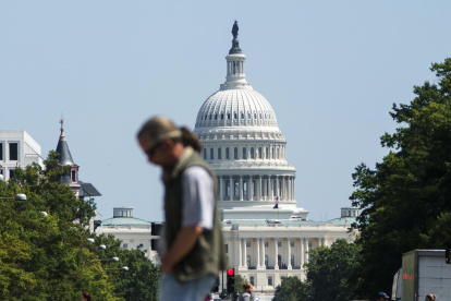 Un transeúnte cruzando la avenida Pensilvania frente al Capitolio de los Estados Unidos, en Washington D. C..