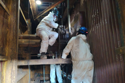 Dos personas trabajan en el proceso de reactivación de la termoeléctrica Trinitaria.