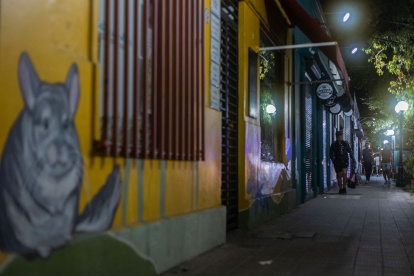 Una persona camina por la acera frente a comercios cerrados en el barrio Italia, distrito de Providencia, Santiago. 30 de octubre de 2025.