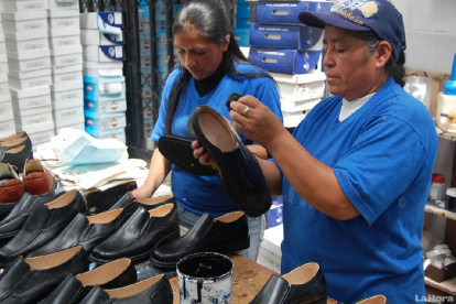 Mujeres trabajando en un taller que elabora zapatos.