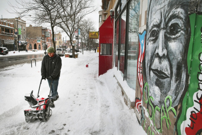 Una persona quita la nieve del frente de la escuela secundaria puertorriqueña Dr. Pedro Albizu Campos en el vecindario de Humboldt Park en Chicago, Illinois.