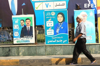 Un hombre pasa por una calle de Bagdad con carteles electorales. Irak celebra elecciones generales del 11 de noviembre.