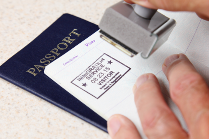 Referencial.Funcionario colocando el sello de ingreso en un pasaporte, en un control migratorio.