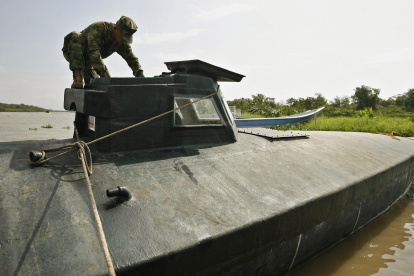 Fotografía de un soldado de la Armada Nacional de Colombia al inspeccionar un submarino utilizado por grupos delictivos.