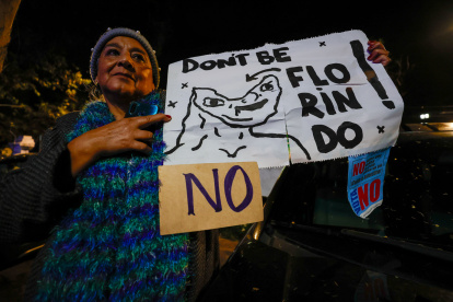 Una simpatizante del Movimiento Revolución Ciudadana sostiene un cartel durante la celebración por el triunfo del "No" en el referéndum este domingo, en Quito (Ecuador).